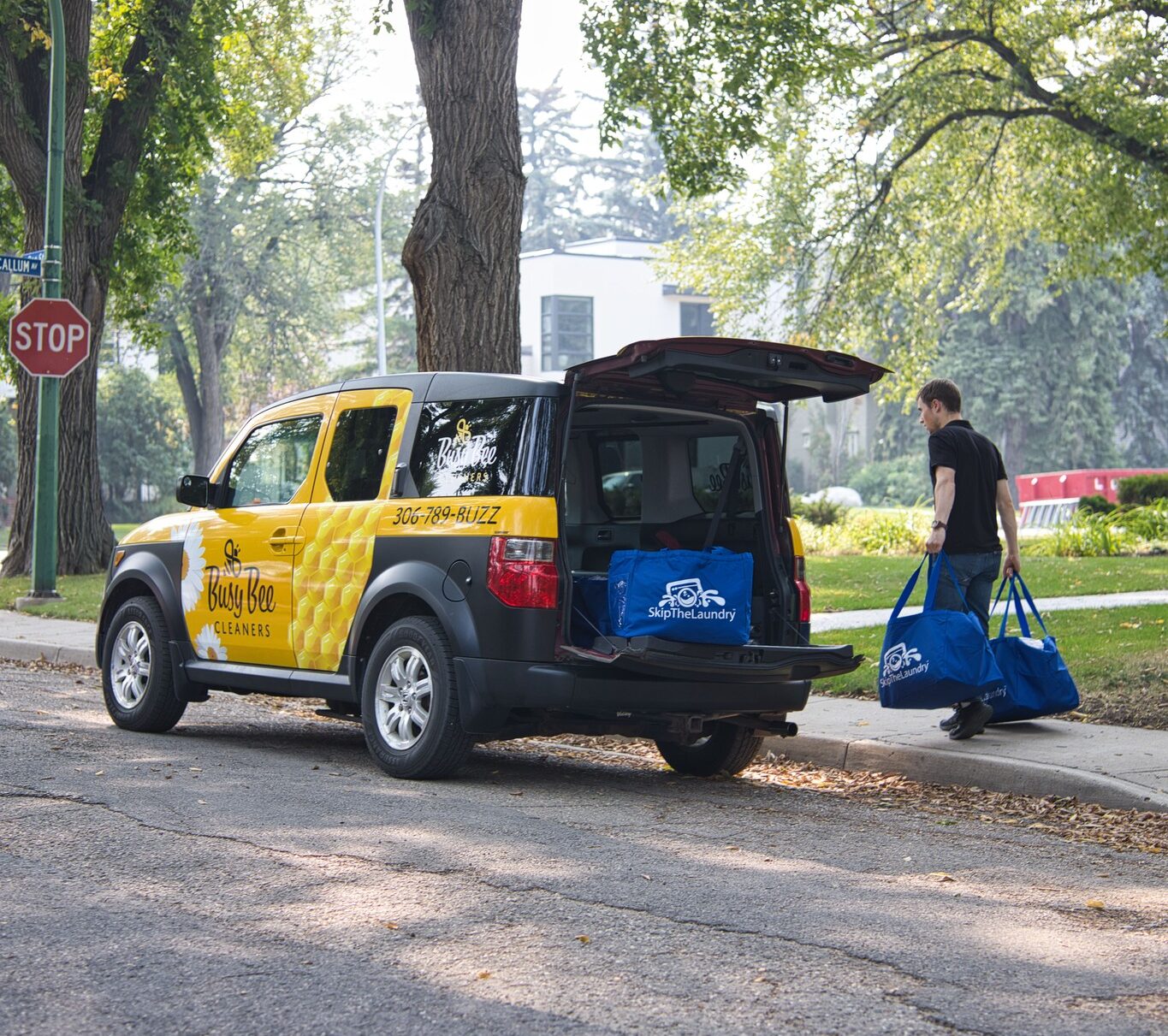 Skip The Laundry delivery vehicle unloading laundry bags after wash and fold with pickup and delivery service